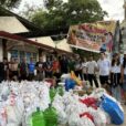 A group of Philippino missionaries stand in front a pile of supplies gathered to help earthquake victims.